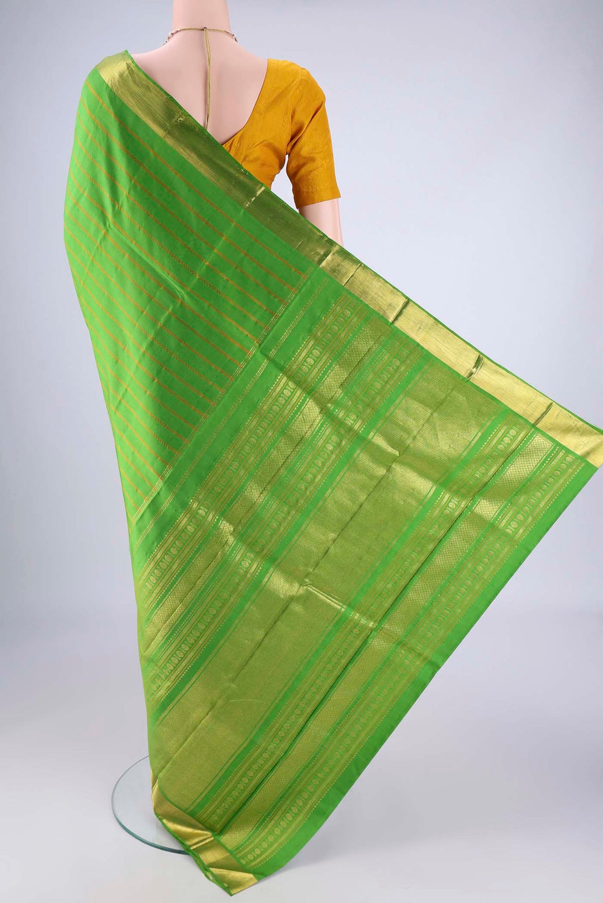 Flat view of Parrot Green Kanjivaram Silk Saree with Veldhari on the body and Zari Border. 