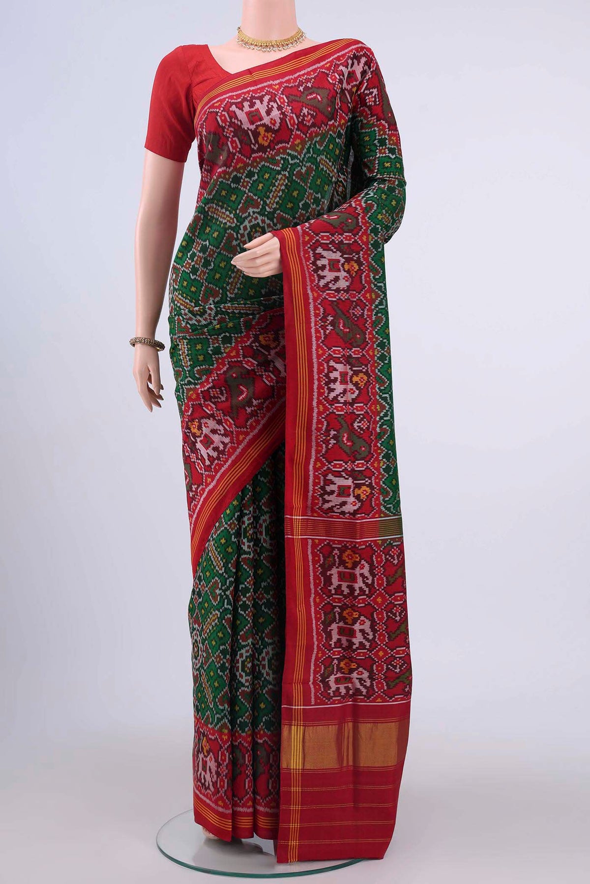 Bottle Green Pochampally Silk Saree with Ikat design on the body and Zari Border displayed on a mannequin