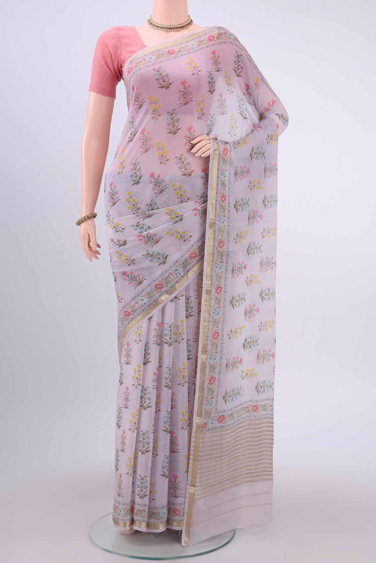 Lavender Mysore Georgette Saree with Floral Print on the body and Zari Border displayed on a mannequin