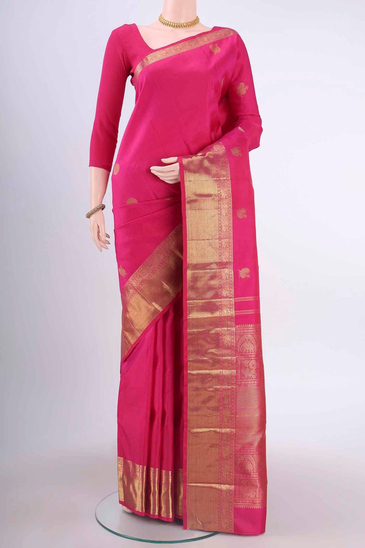 Pure Silk Pure Zari Rani Pink Kanchipuram Saree with Zari Butta on the body and Zari Border displayed on a mannequin