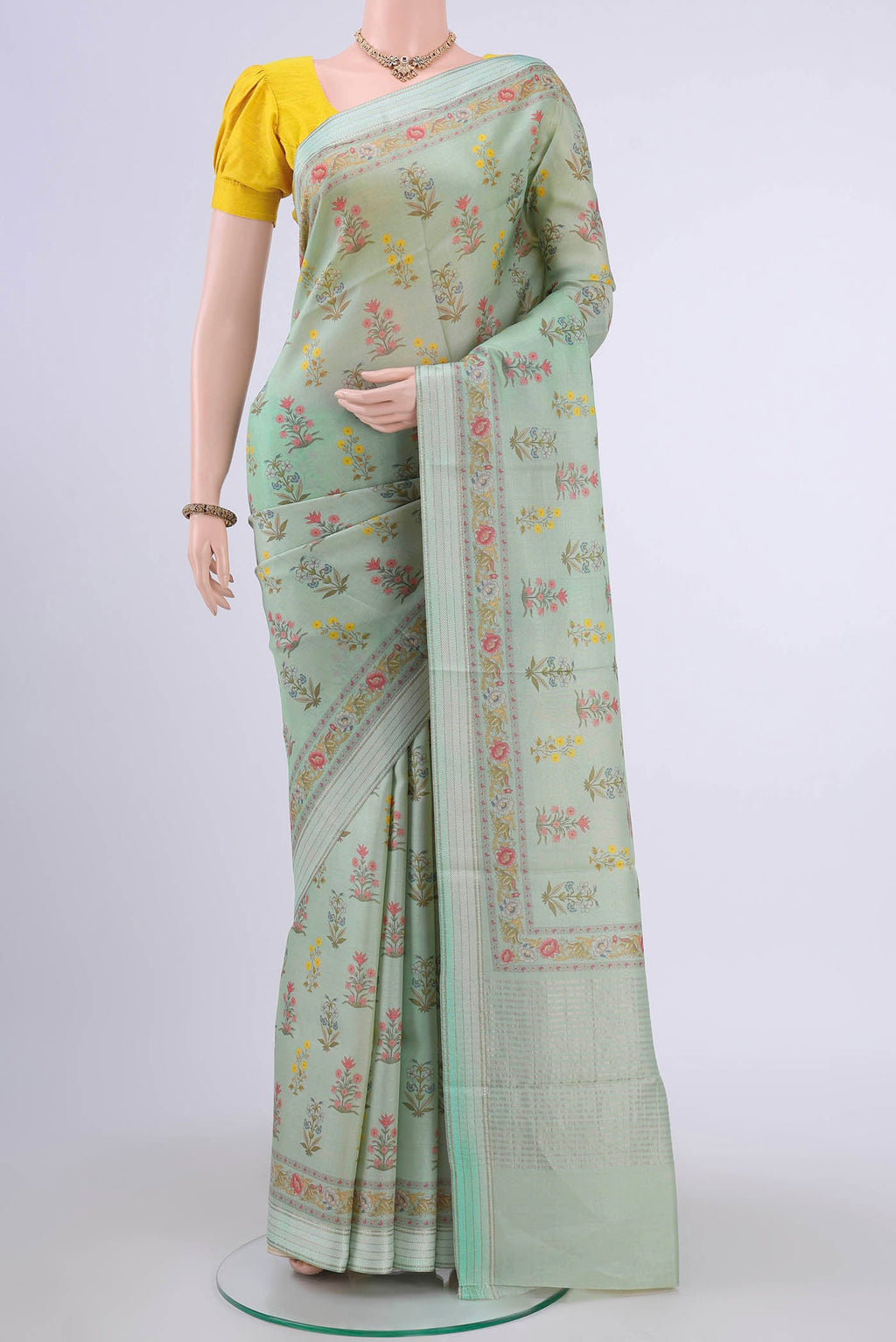 Mint Green Tussar Silk Saree with Floral Print on the body and Zari And Thread Border displayed on a mannequin