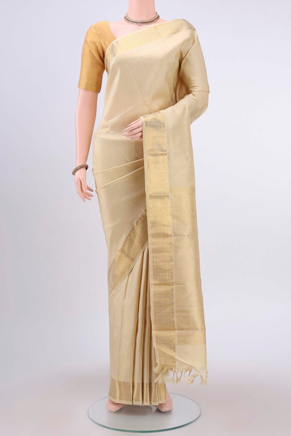 Cream Kanchipuram Silk Saree with Zari Brocade on the body and Zari Border displayed on a mannequin