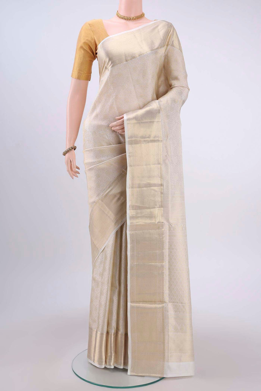 Off White Soft Silk Saree with Zari Brocade on the body and Zari Border displayed on a mannequin