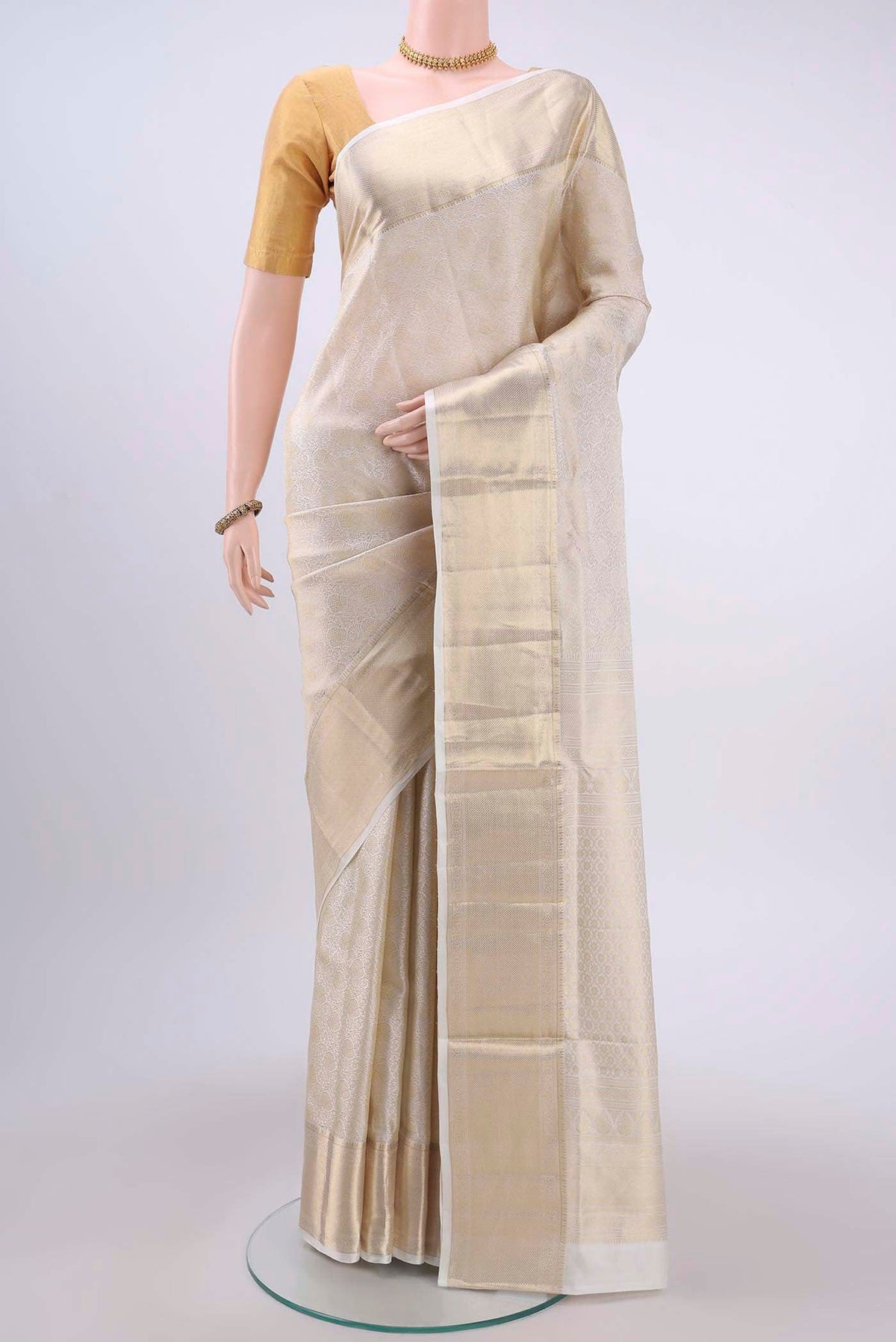 Off White Soft Silk Saree with Zari Brocade on the body and Zari Border displayed on a mannequin