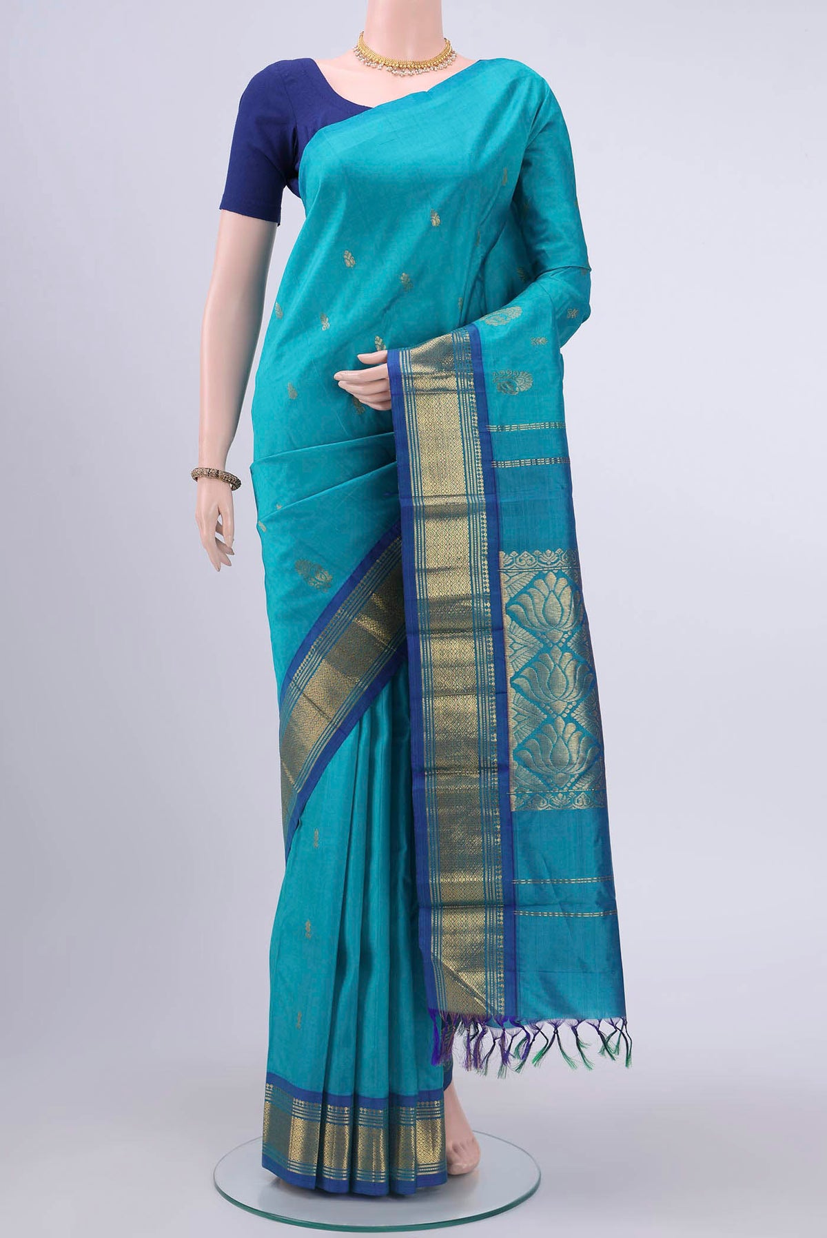 Turquoise Kanchipuram Silk Saree with Zari Butta on the body and One Side Border displayed on a mannequin