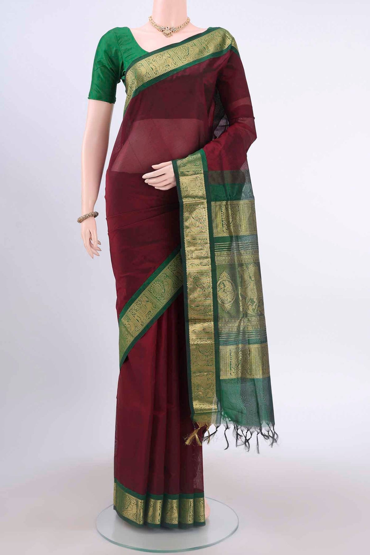 Maroon Silk Cotton Saree with Plain Body and Zari Border displayed on a mannequin