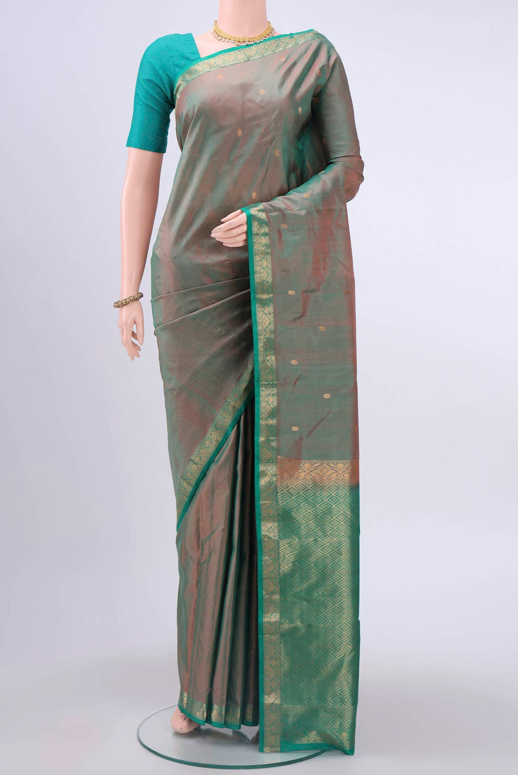Green with Coral Color Kanchipuram Silk Saree with Zari Butta on the body and Zari Border displayed on a mannequin