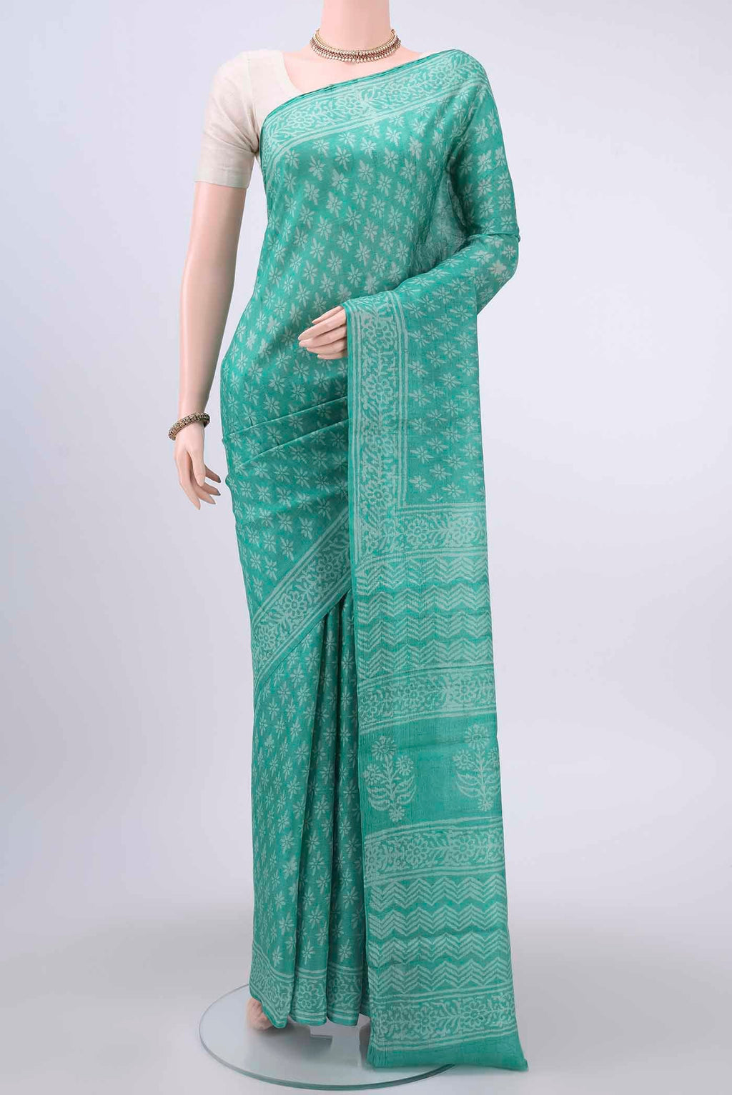 Turquoise Tussar Silk Saree with Printed design on the body and Printed Border displayed on a mannequin