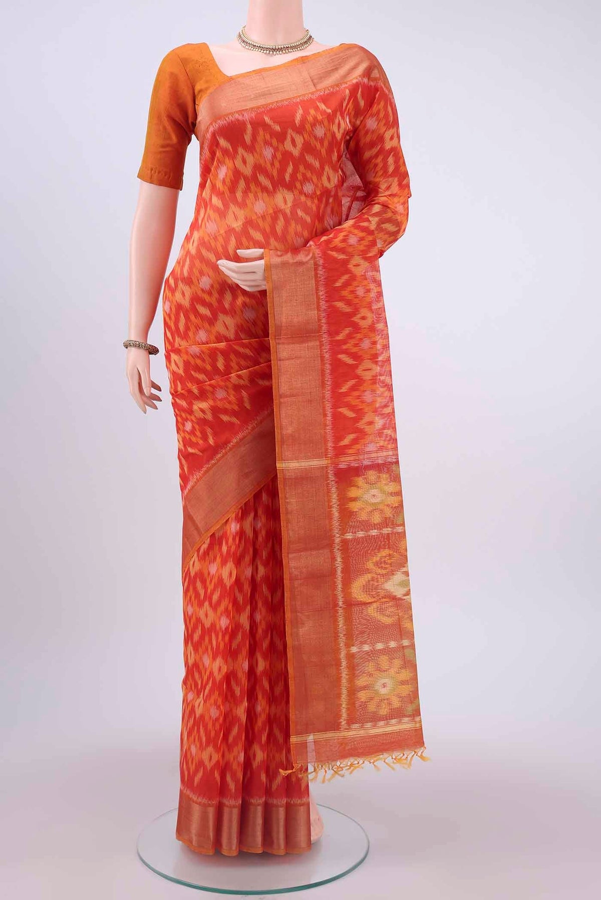 Orange Kora Cotton Saree with Ikat design on the body and Zari Border displayed on a mannequin