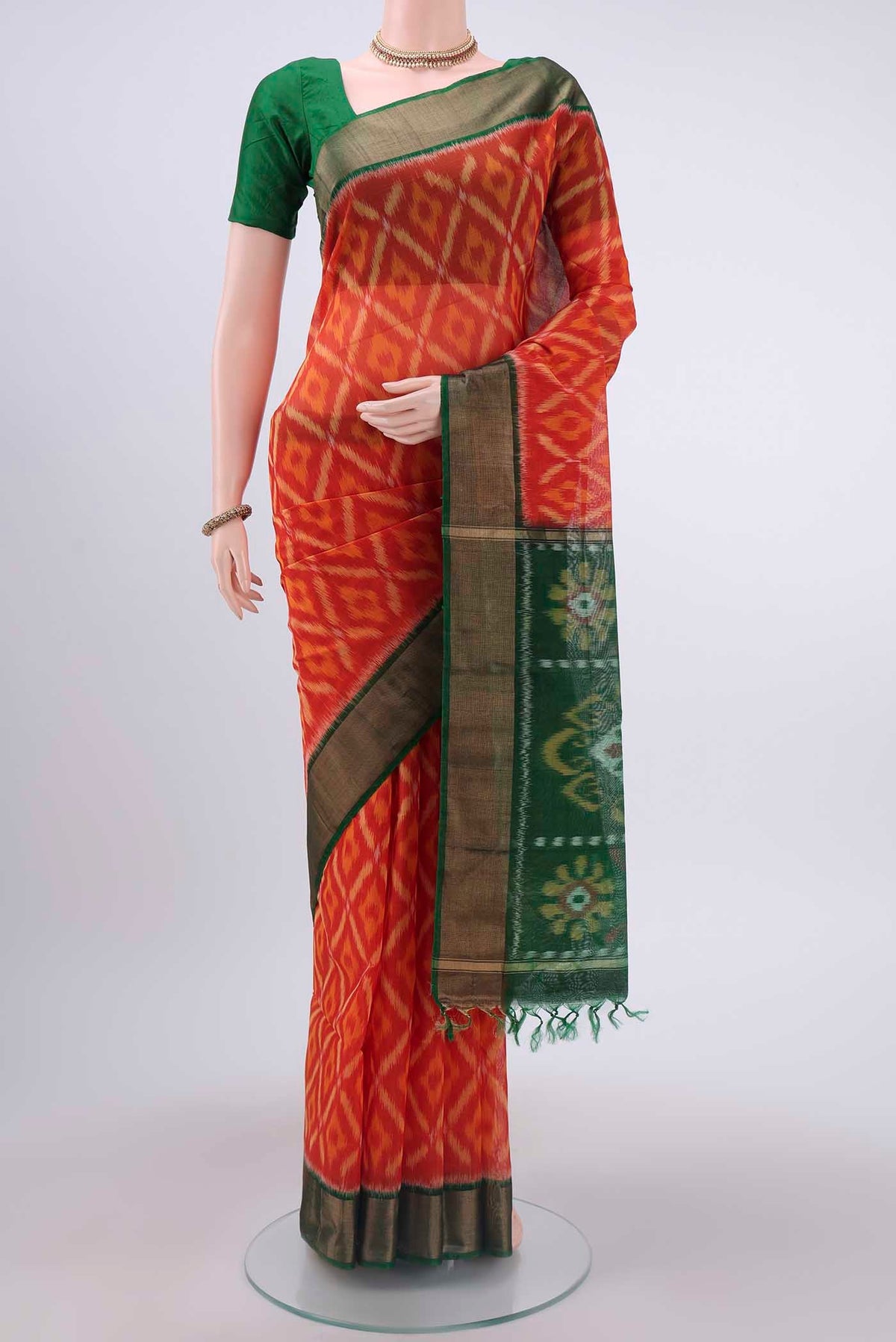 Brick Orange Kora Cotton Saree with Ikat design on the body and Zari Border displayed on a mannequin