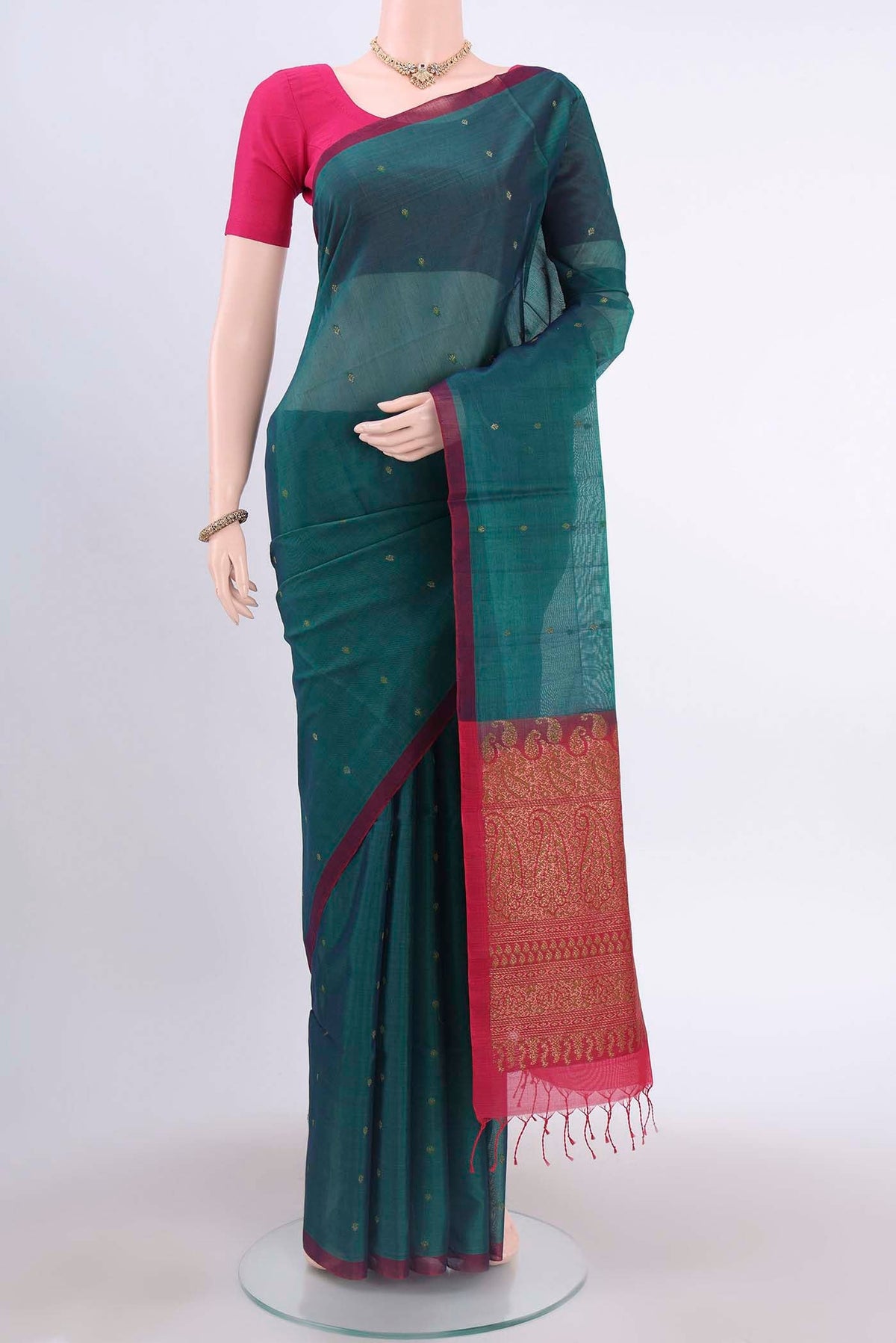 Bottle Green Kora Cotton Saree with Zari Butta on the body and Zari Border displayed on a mannequin