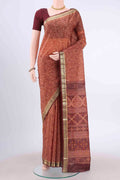 Rust Printed Silk Saree with Floral Print on the body and Zari Border displayed on a mannequin