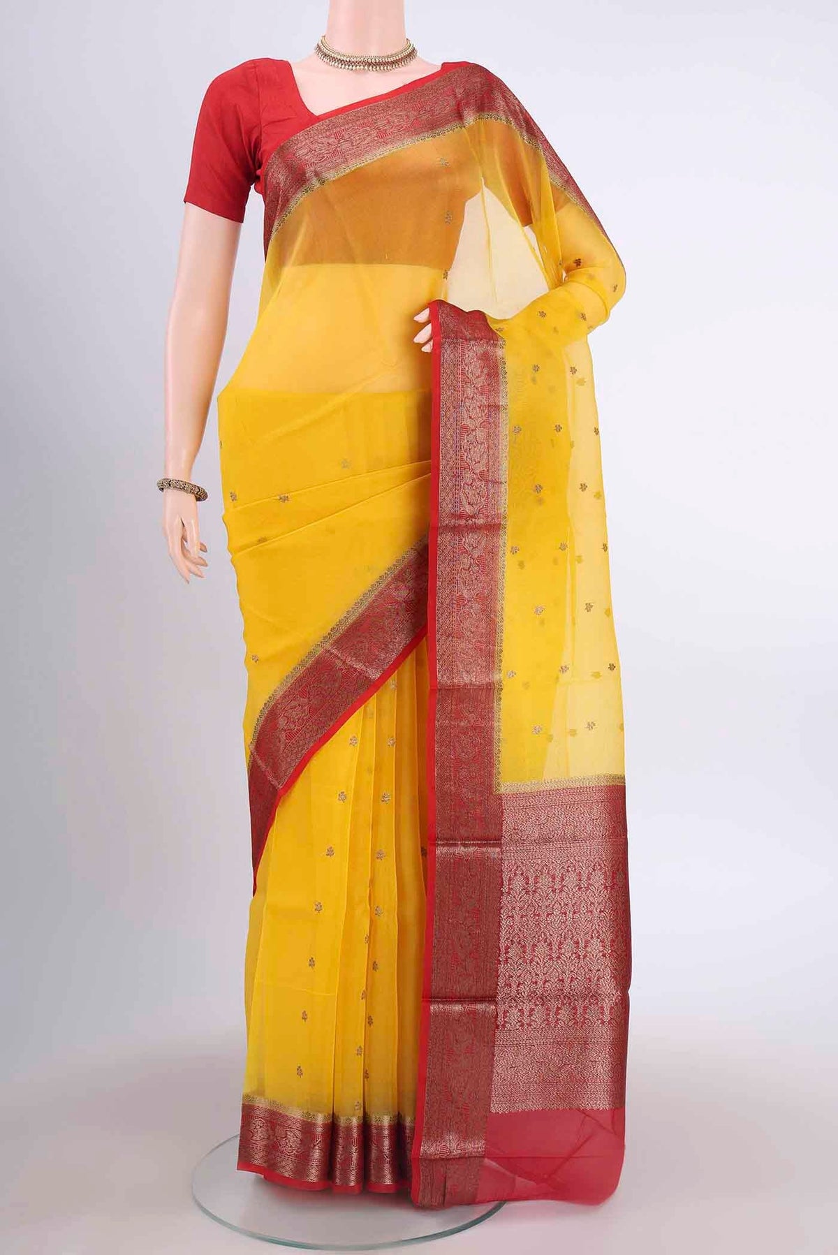 Yellow Organza Silk Saree with Zari Butta on the body and Zari Border displayed on a mannequin