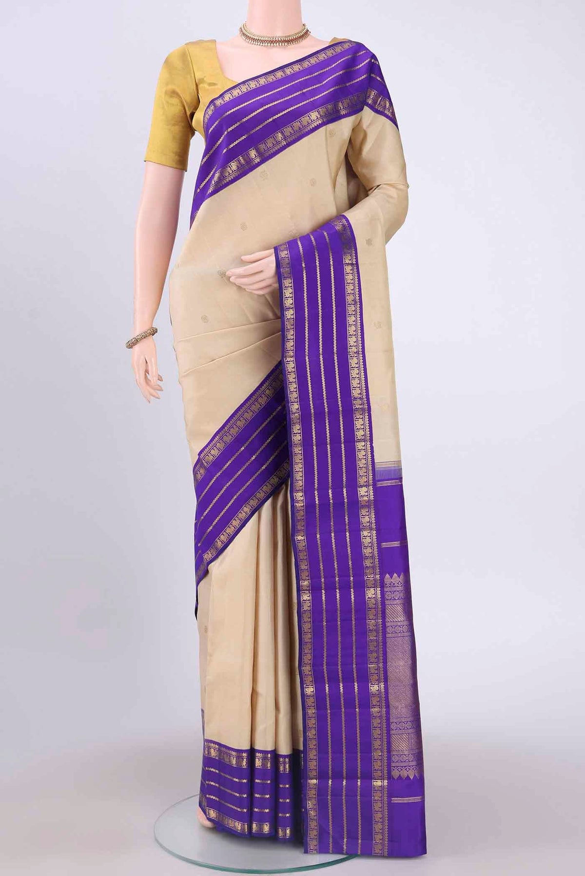 Pure Silk Pure Zari Off White Kanchipuram Saree with Zari Butta on the body and Zari Border displayed on a mannequin