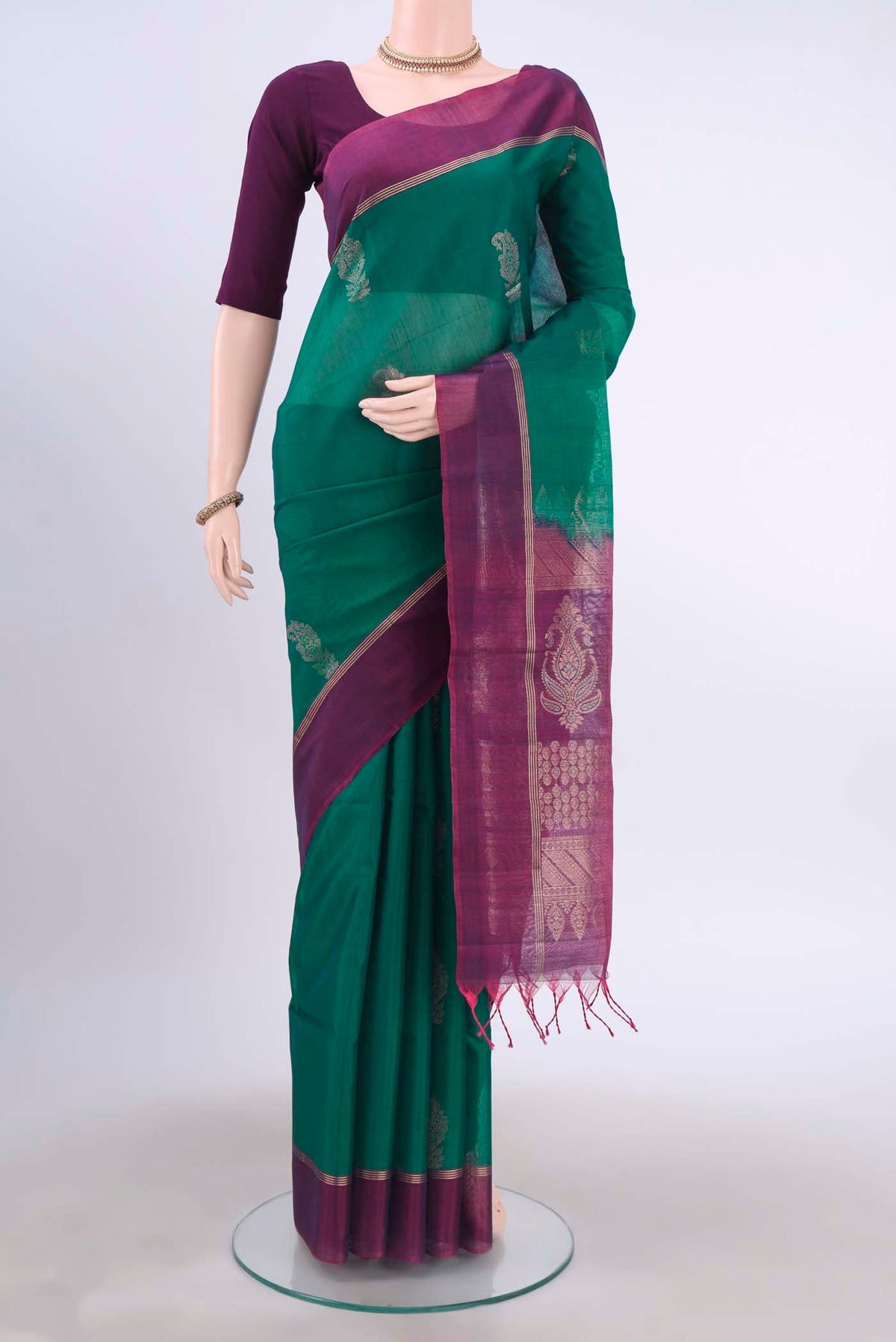 Bottle Green Kora Cotton Saree with Zari Butta on the body and Zari Border displayed on a mannequin