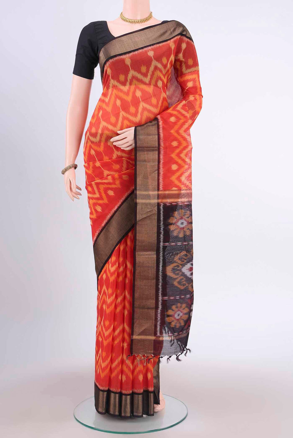 Brick Orange Kora Cotton Saree with Ikat Print on the body and Zari Border displayed on a mannequin
