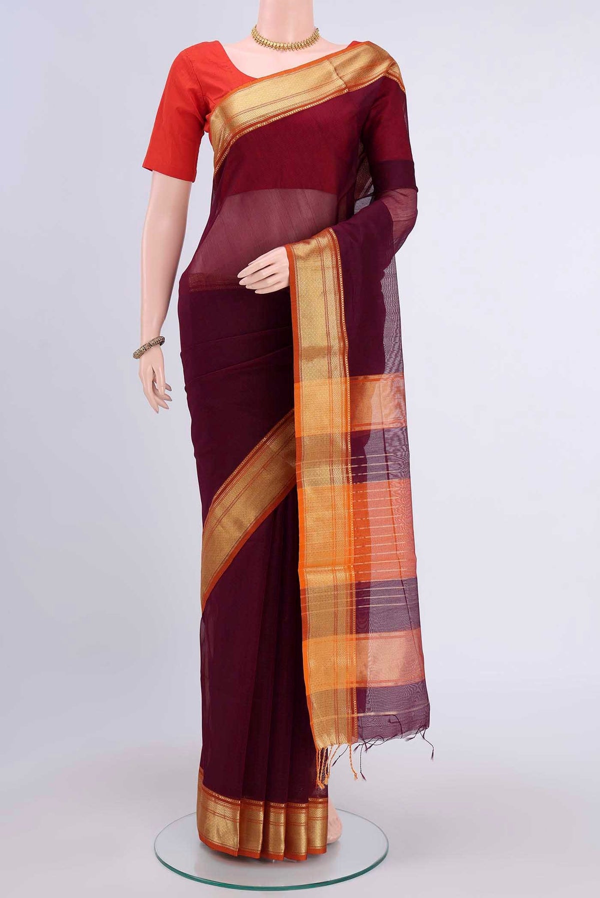 Burgundy Maheshwari Silk Cotton Saree with Plain Body and Zari Border displayed on a mannequin
