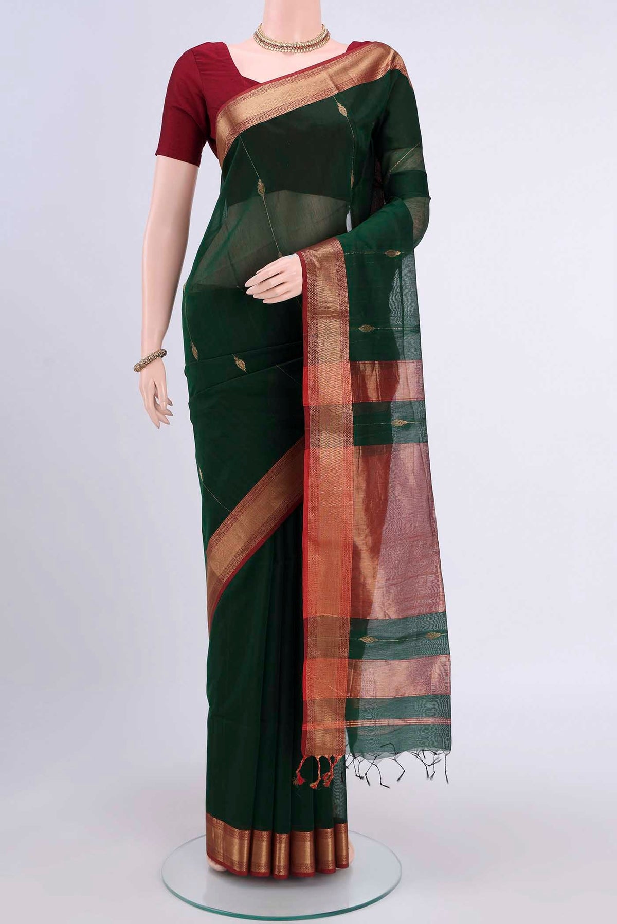 Bottle Green Maheshwari Silk Cotton Saree with Zari Butta on the body and Zari Border displayed on a mannequin