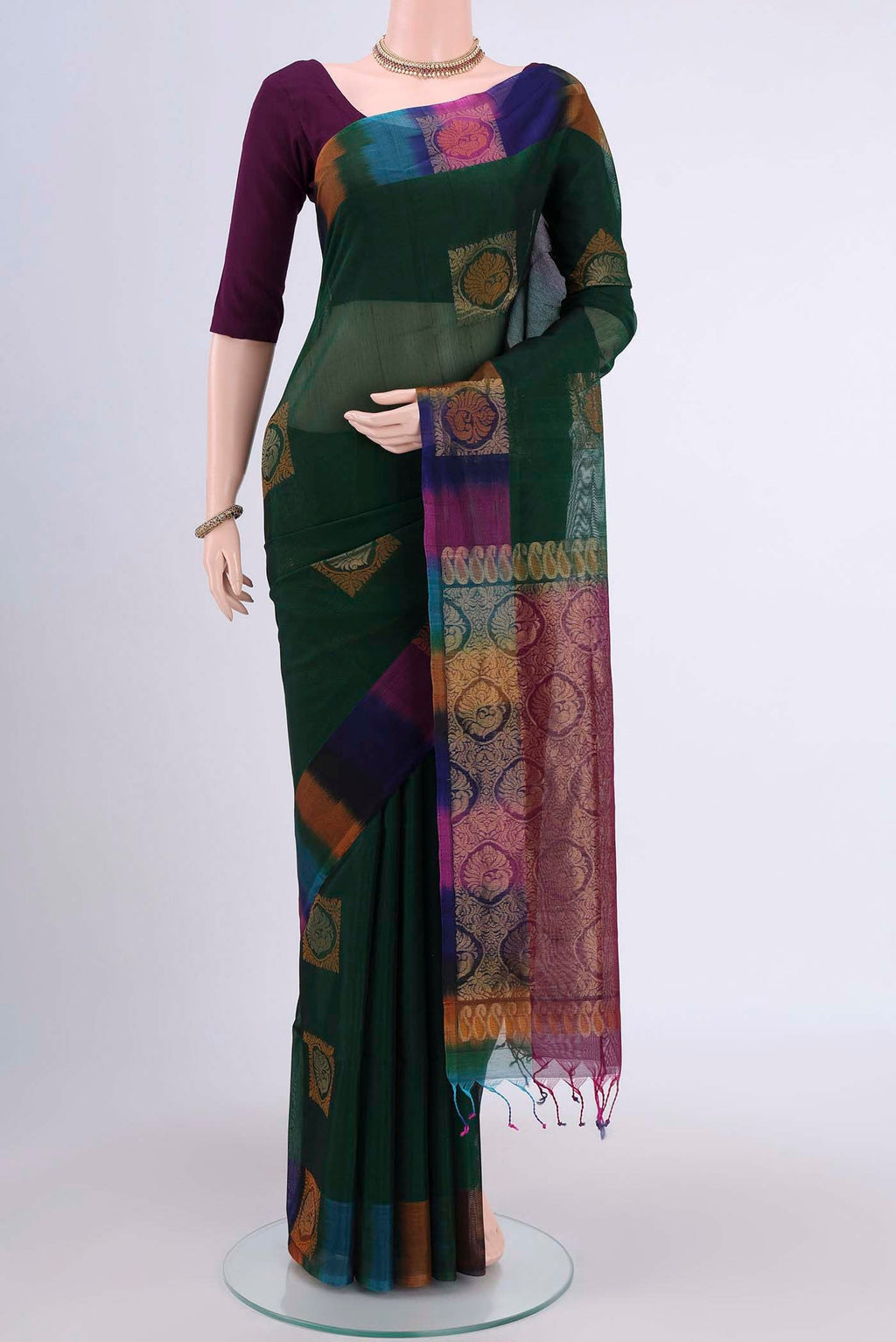 Bottle Green Kora Cotton Saree with Zari Butta on the body and Zari Border.  displayed on a mannequin