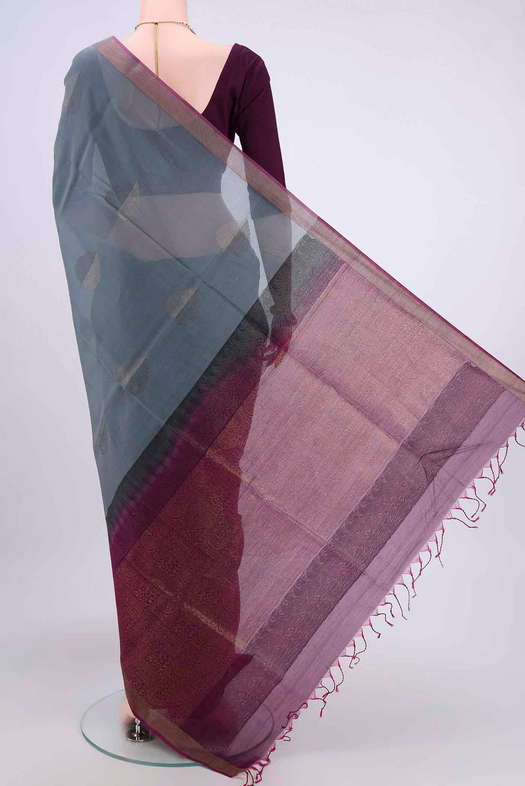 Flat view of Grey Kora Cotton Saree with Zari Butta on the body and Zari Border. 