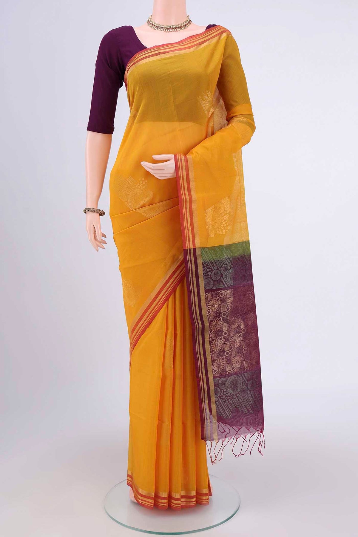 Yellow Kora Cotton Saree with Zari Butta on the body and Zari Border.  displayed on a mannequin