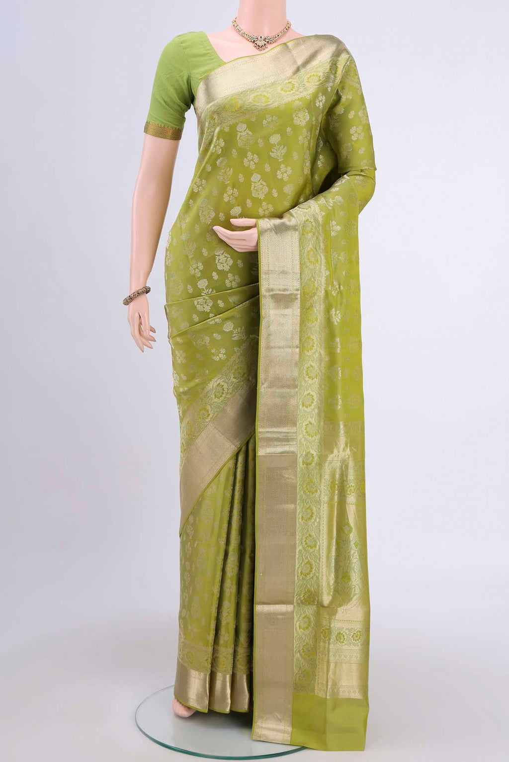 Light Green Soft Silk Saree with Zari Butta on the body and Zari Border displayed on a mannequin