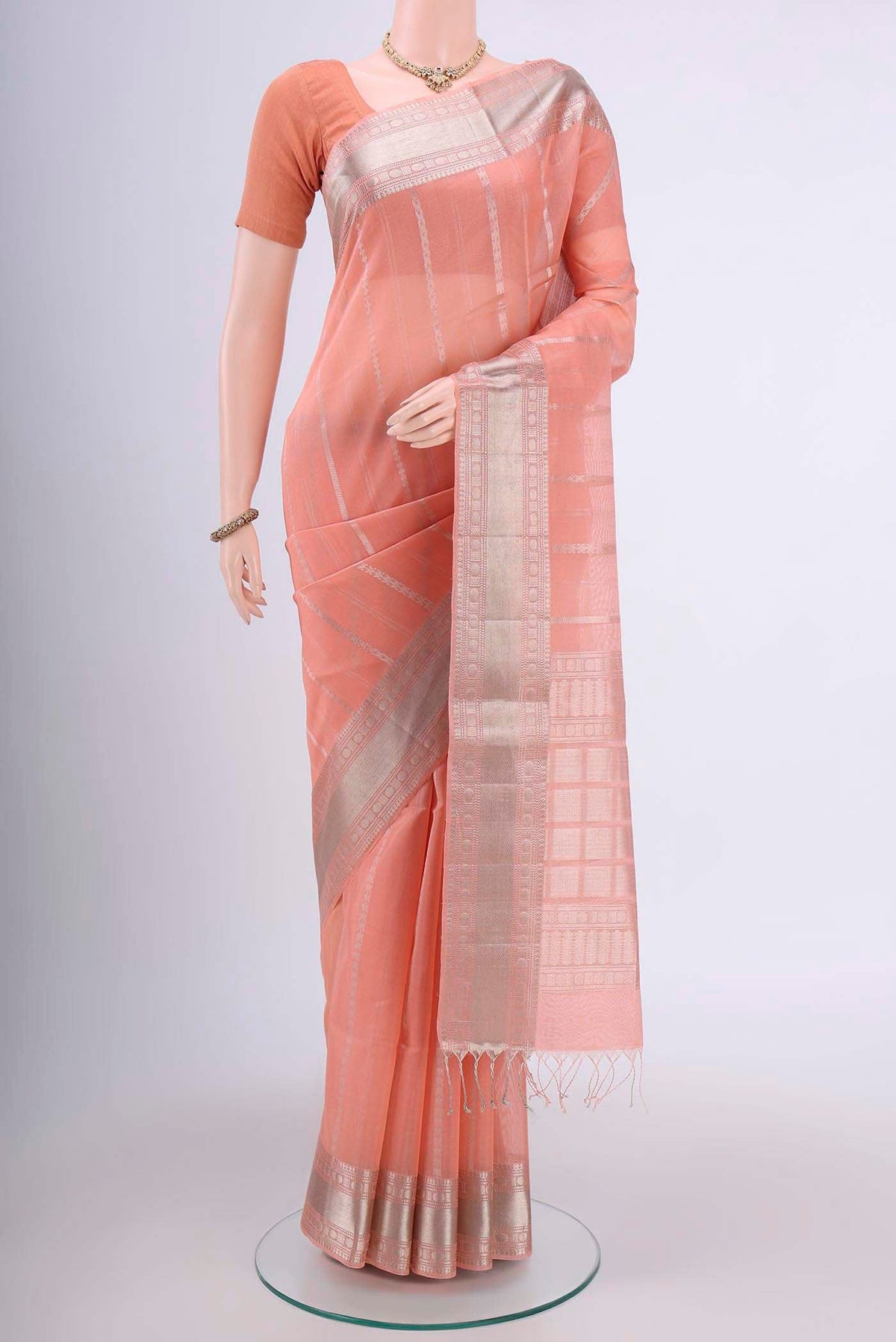 Peach Kora Cotton Saree with Zari Butta on the body and Zari Border.  displayed on a mannequin