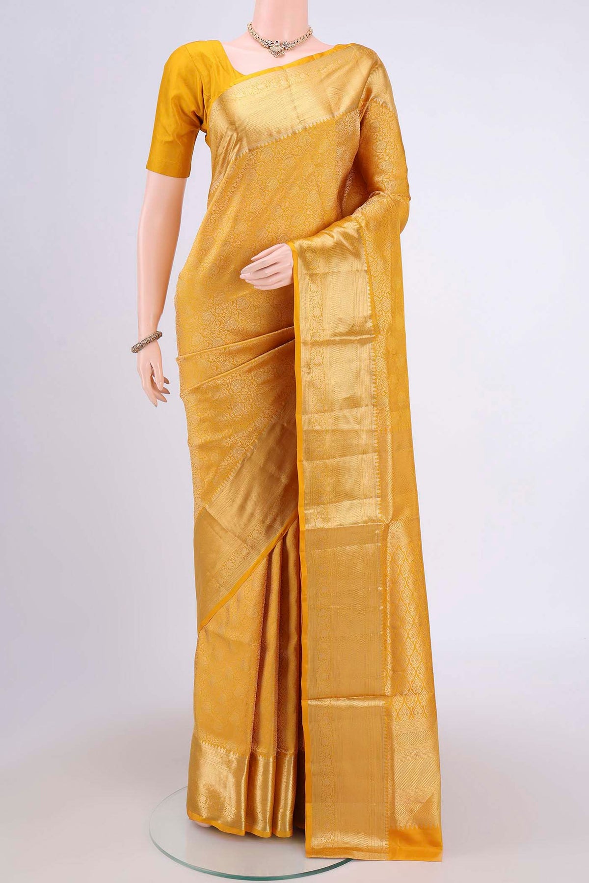 Mustard Soft Silk Saree with Zari Brocade on the body and Zari Border.  displayed on a mannequin