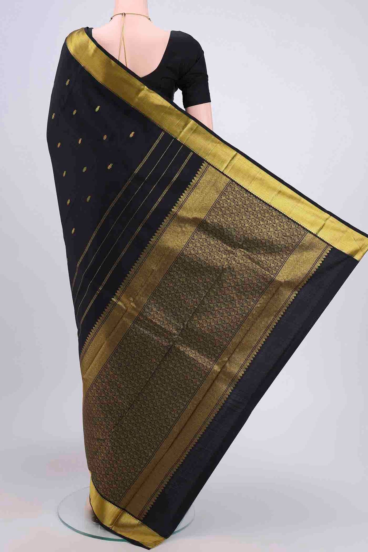 Flat view of Black Kanchipuram Saree with Zari Butta on the body and Zari Border. 