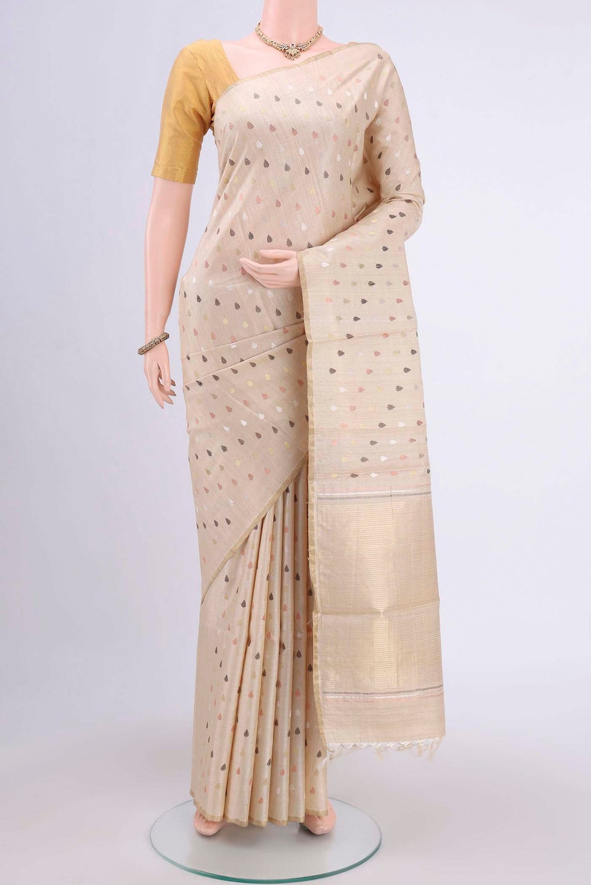 Beige Tussar Silk Saree with Zari And Thread Butta on the body and Thin Zari Line.  displayed on a mannequin