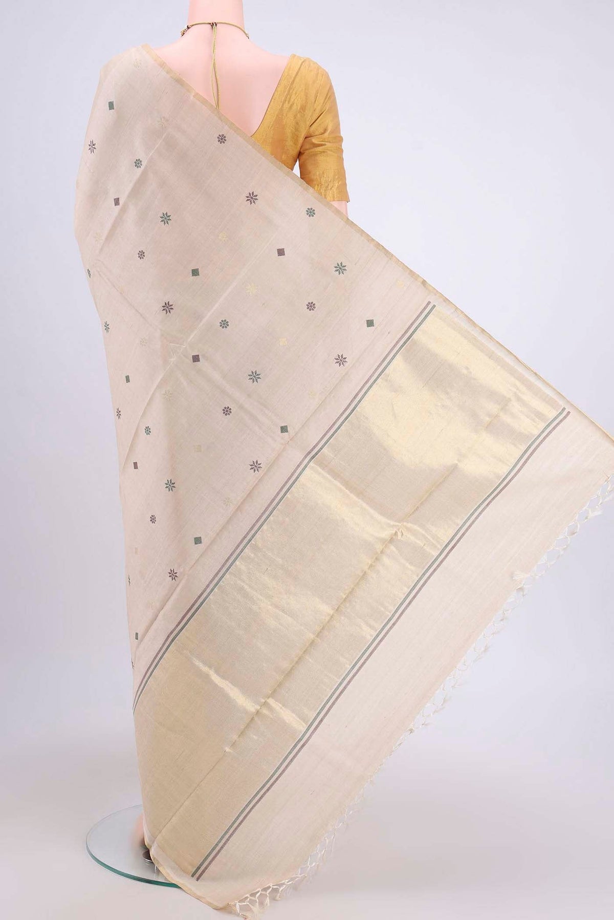 Flat view of Beige Tussar Silk Saree with Zari And Thread Butta on the body and Thin Zari Line. 