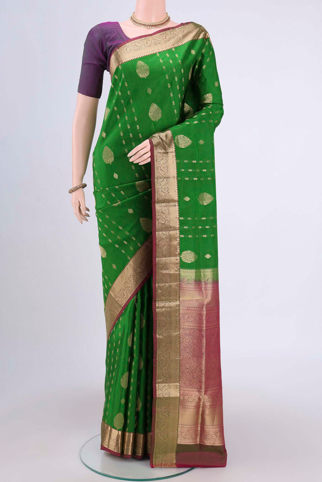 Green Soft Silk Saree with Zari Butta on the body and Zari Border.  displayed on a mannequin