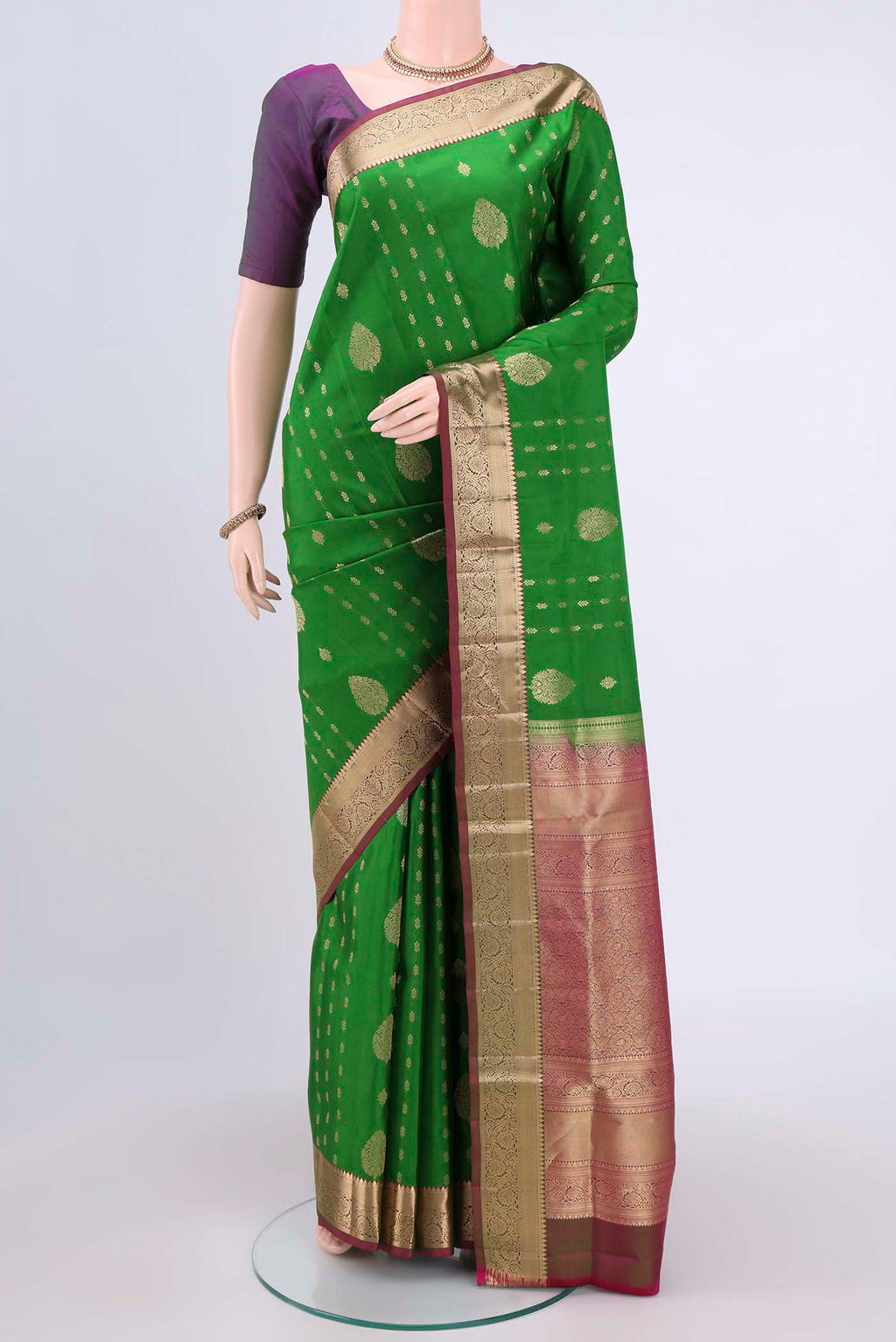 Green Soft Silk Saree with Zari Butta on the body and Fancy Border.  displayed on a mannequin