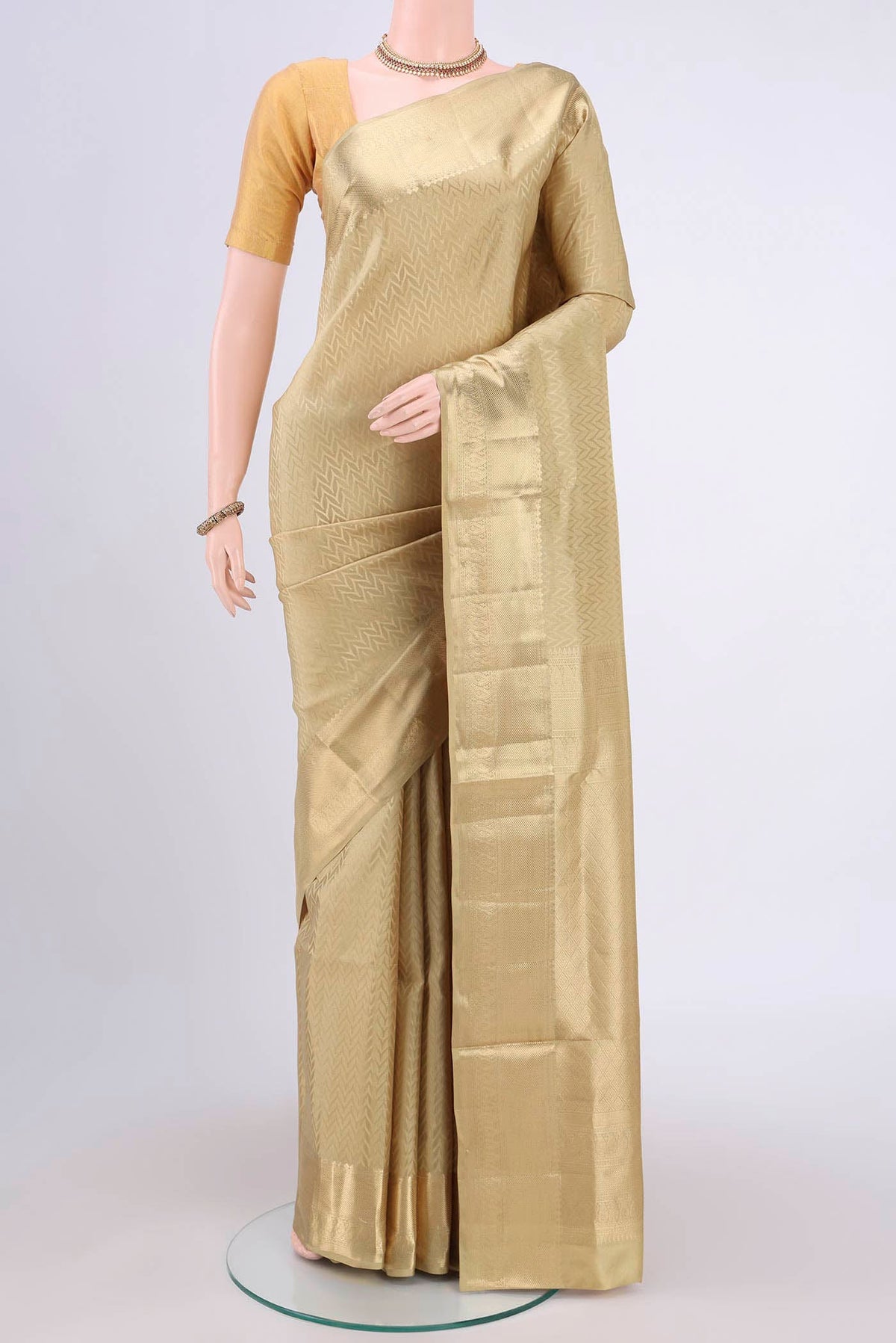 Dark Beige Soft Silk Saree with Zig Zag design on the body and Zari Border.  displayed on a mannequin