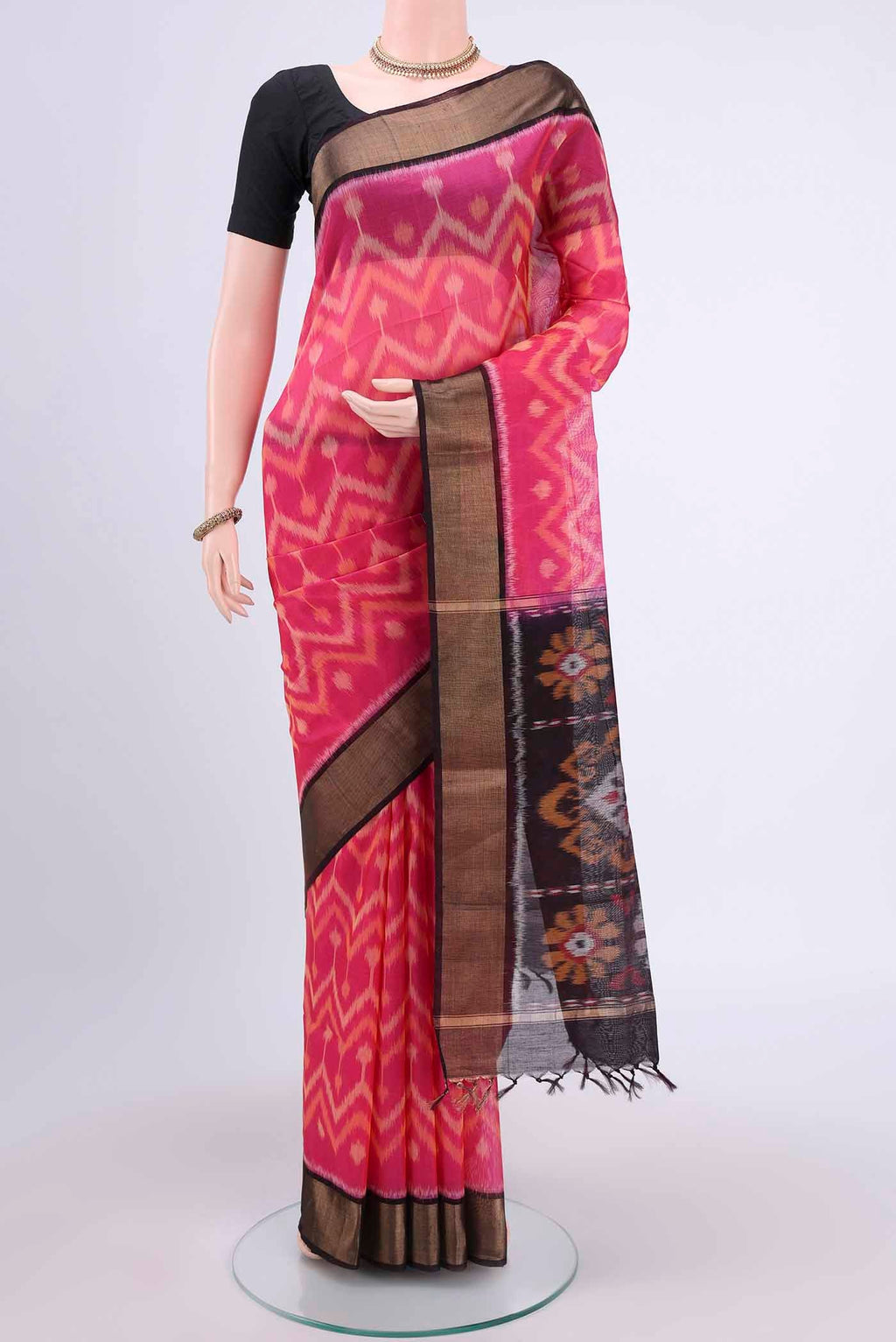 Rani Pink Kora Cotton Saree with Ikat design on the body and Zari Border displayed on a mannequin