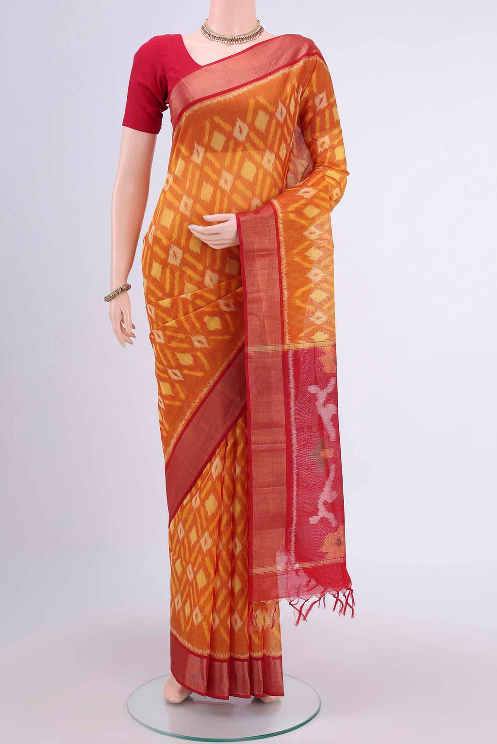 Brick Orange Kora Cotton Saree with Ikat design on the body and Zari Border displayed on a mannequin