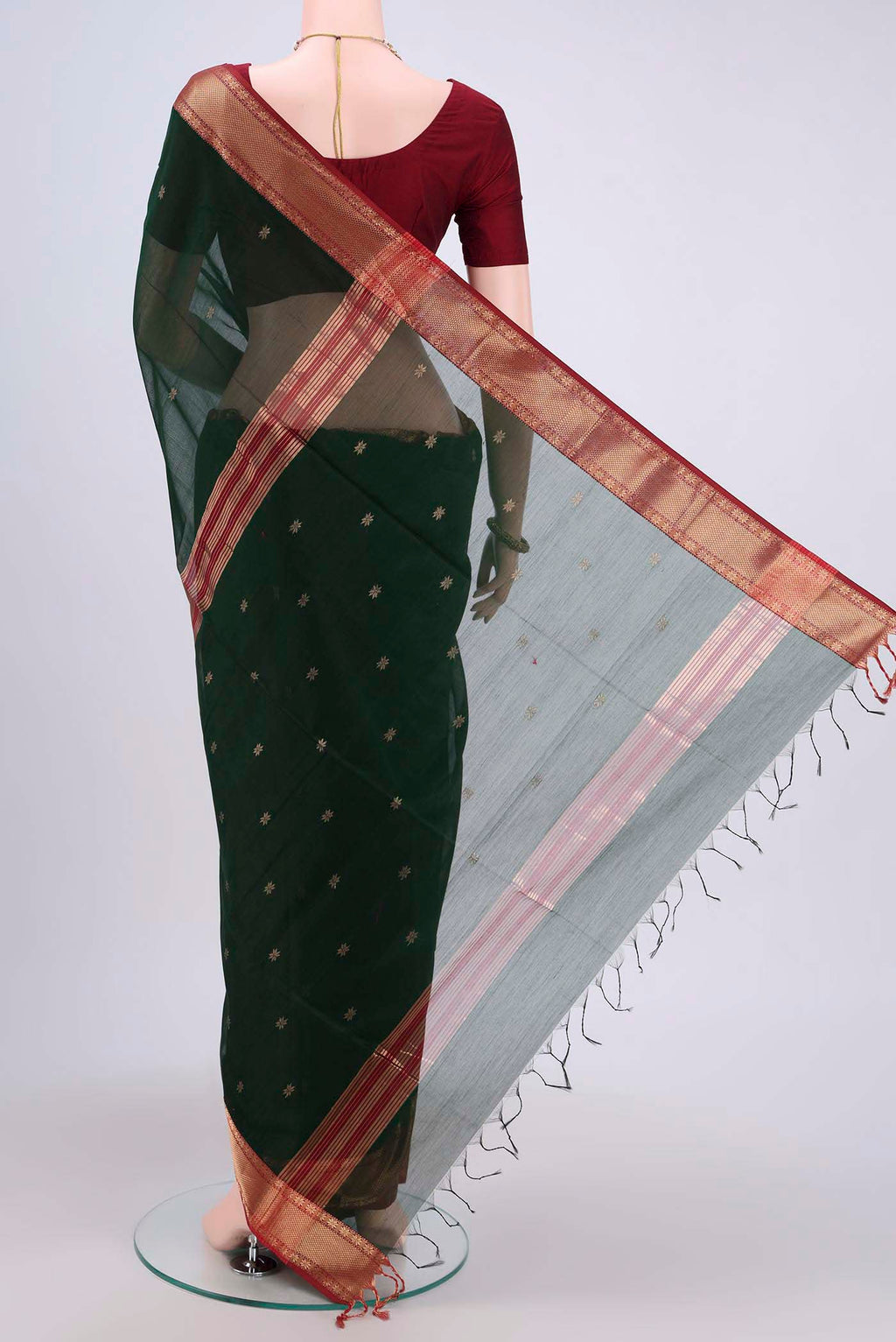 Flat view of Bottle Green Maheshwari Silk Cotton Saree with Zari Butta on the body and Zari Border. 