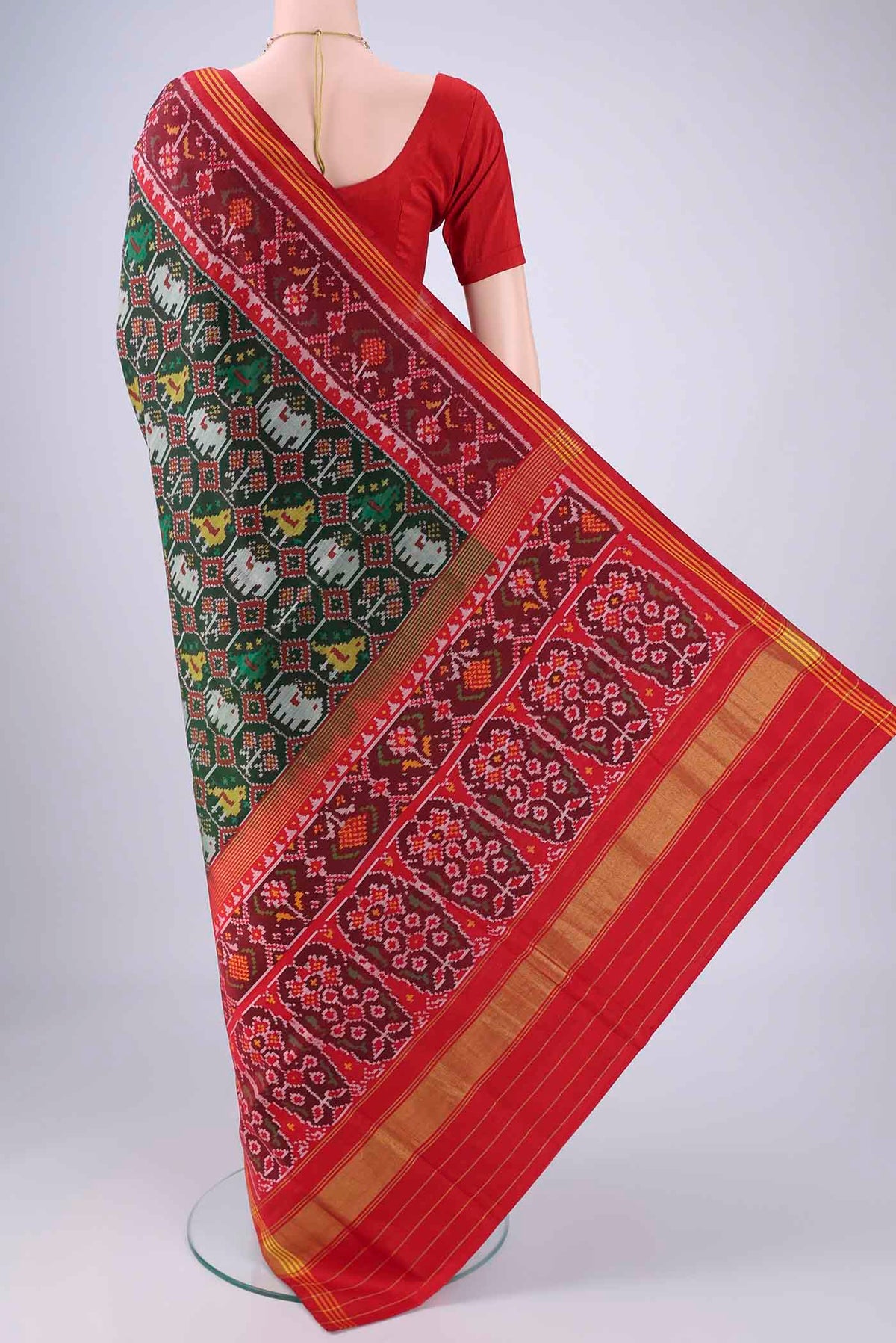 Flat view of Bottle Green Rajkot Patola Silk Saree with Pure Ikat on the body and Ikat Border. 