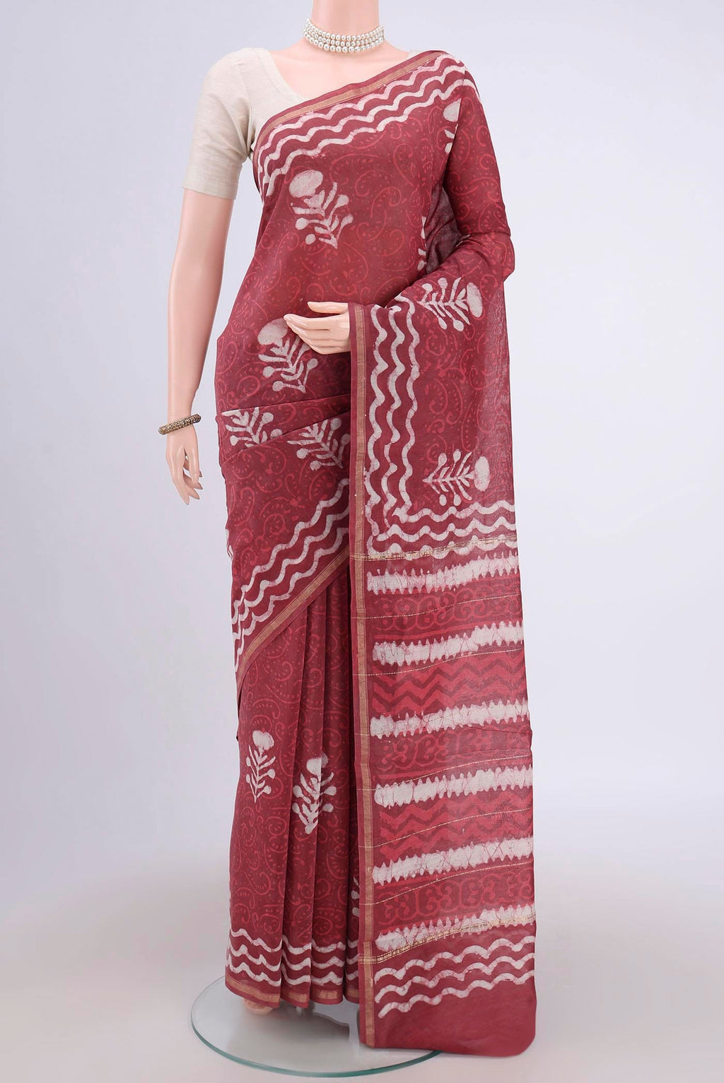 Coral Maheshwari Silk Cotton Saree with Batik Print on the body and Zari Border.  displayed on a mannequin
