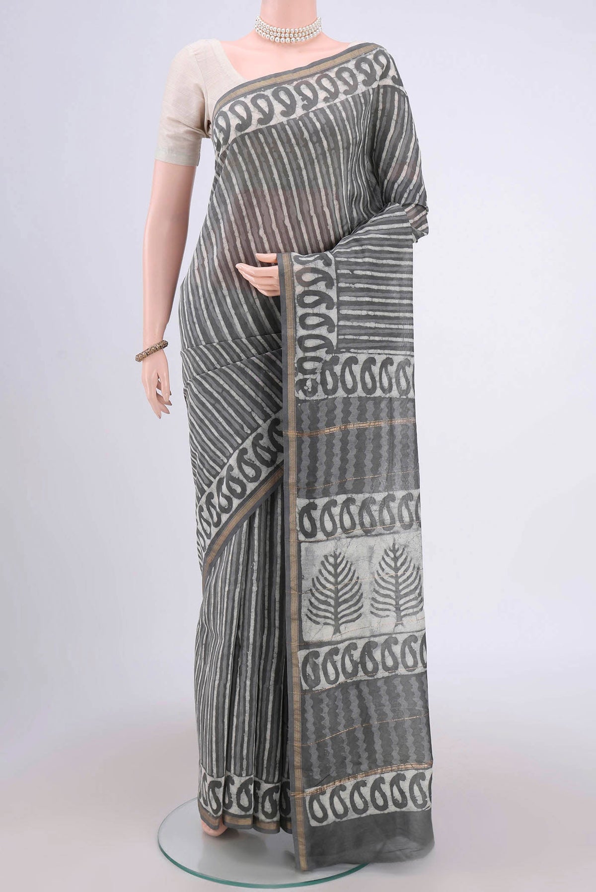 Grey Maheshwari Silk Cotton Saree with Batik Print on the body and Zari Border.  displayed on a mannequin