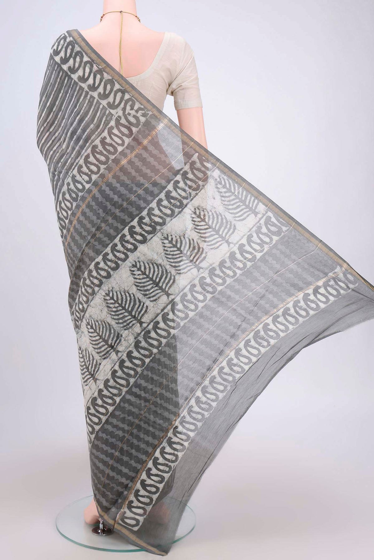Flat view of Grey Maheshwari Silk Cotton Saree with Batik Print on the body and Zari Border. 