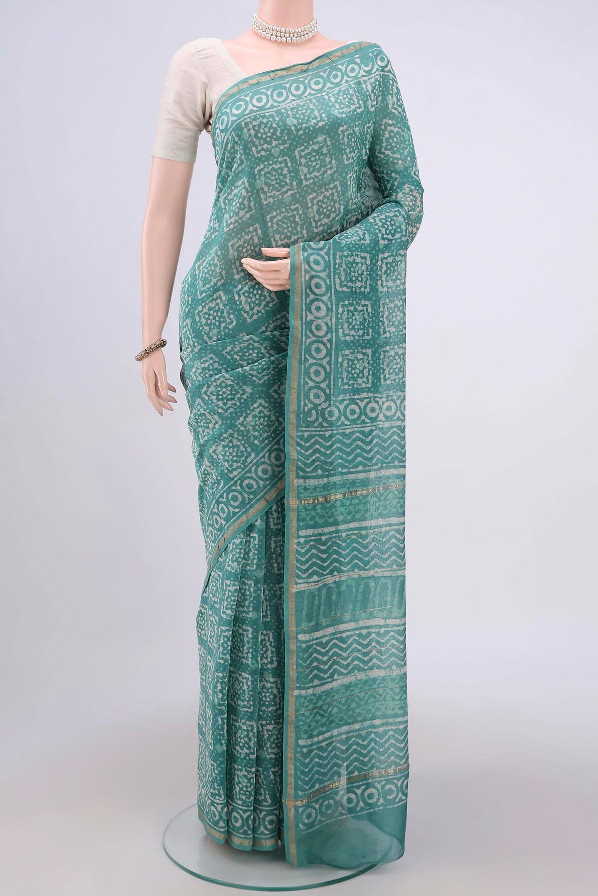 Turquoise Maheshwari Silk Cotton Saree with Batik Print on the body and Zari Border.  displayed on a mannequin