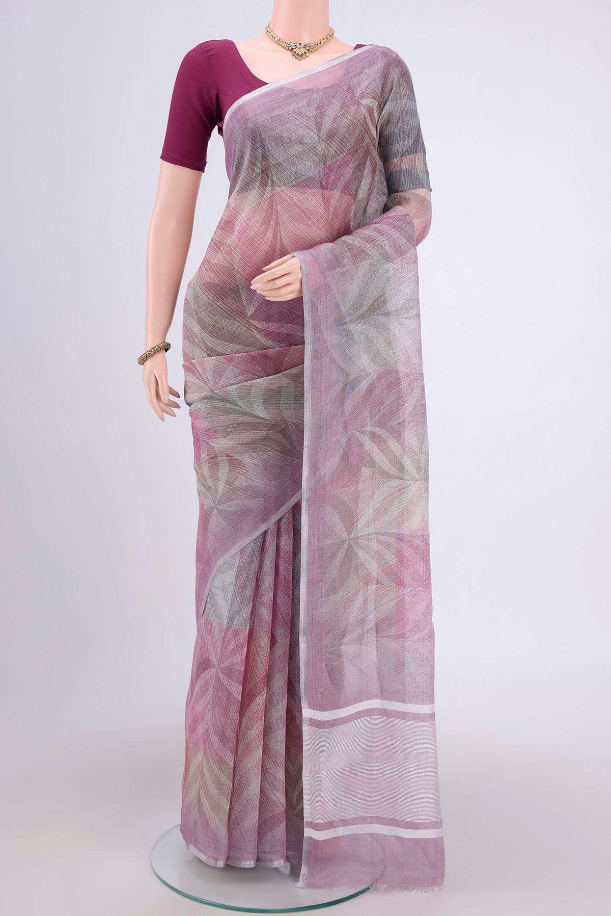 Mauve Linen Cotton Saree with Floral Print on the body and Zari Border.  displayed on a mannequin