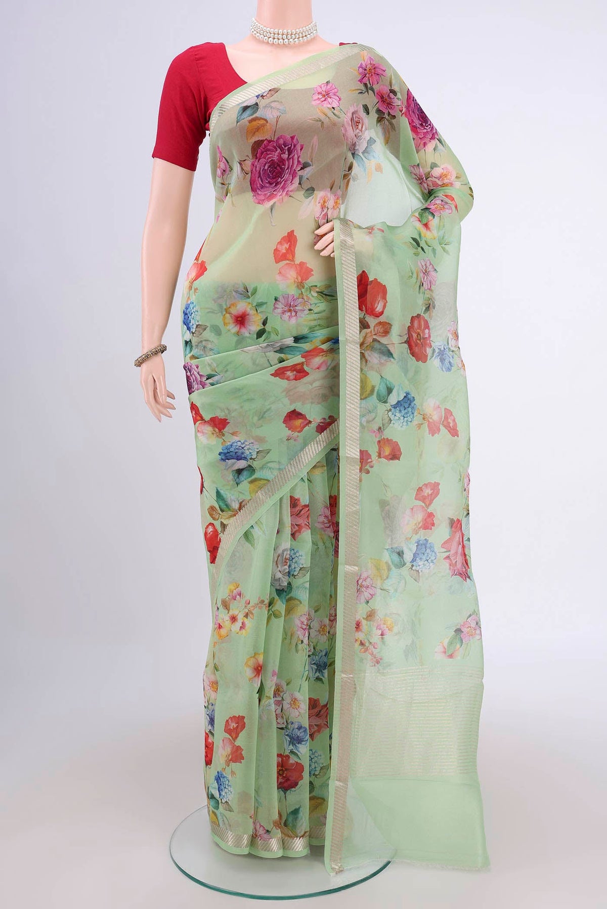 Light Green Organza Silk Saree with Floral Print on the body and Zari Border.  displayed on a mannequin