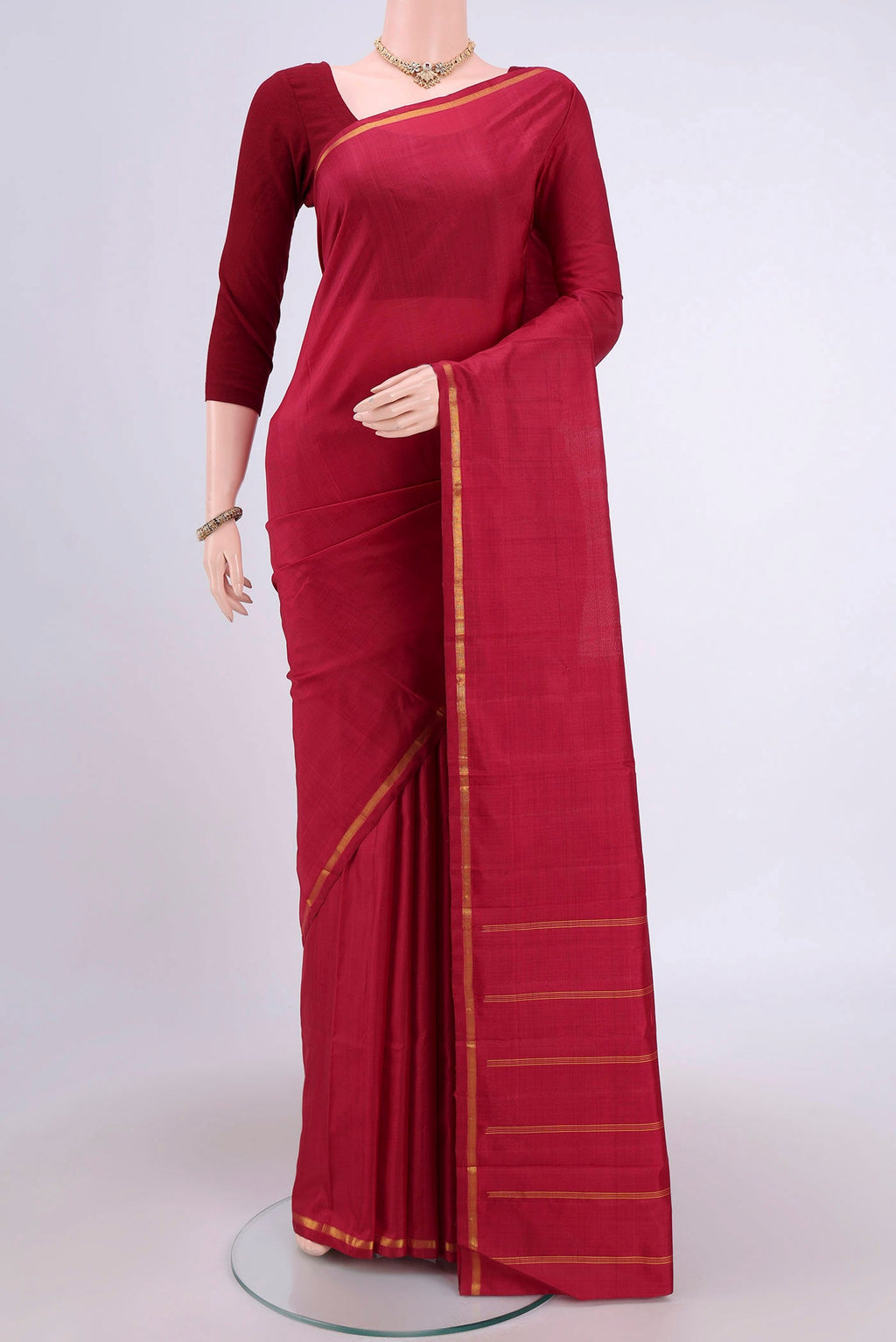 Maroon Kanchipuram Silk Saree with Plain Body and Zari Border.  displayed on a mannequin