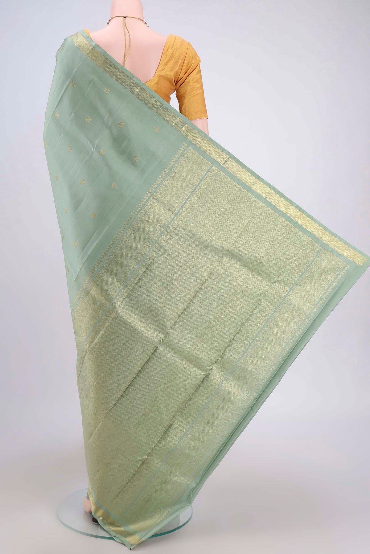 Flat view of Sage Green Kanchipuram Saree with Zari Butta on the body and Zari Border. 