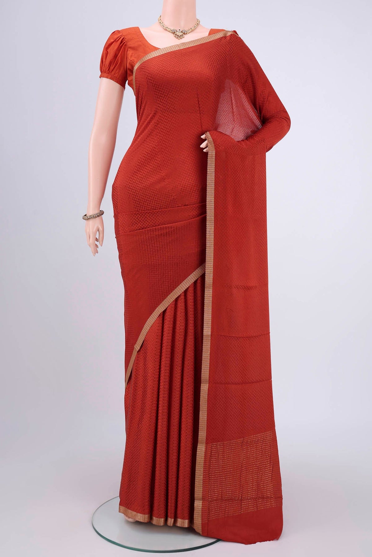 Rust Mysore Crepe Saree with Jacquard design on the body and Zari Border.  displayed on a mannequin
