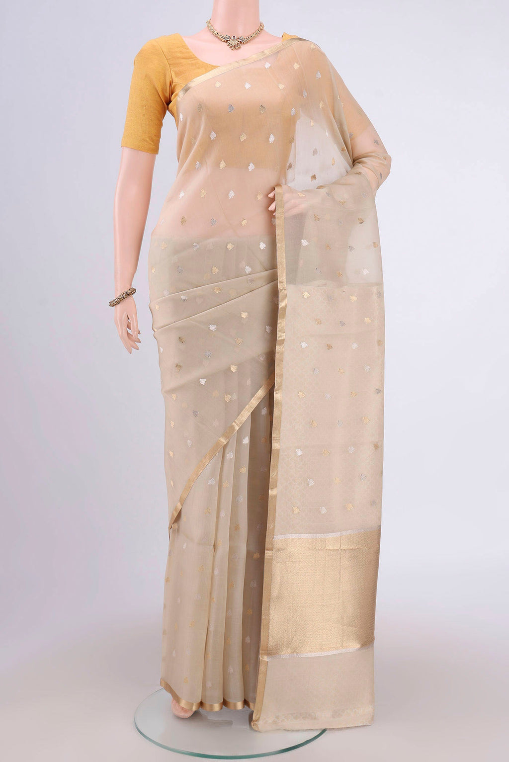Beige Banarasi Katan Silk Saree with Zari Butta on the body and Zari Border.  displayed on a mannequin