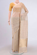 Beige Banarasi Katan Silk Saree with Zari Butta on the body and Zari Border.  displayed on a mannequin