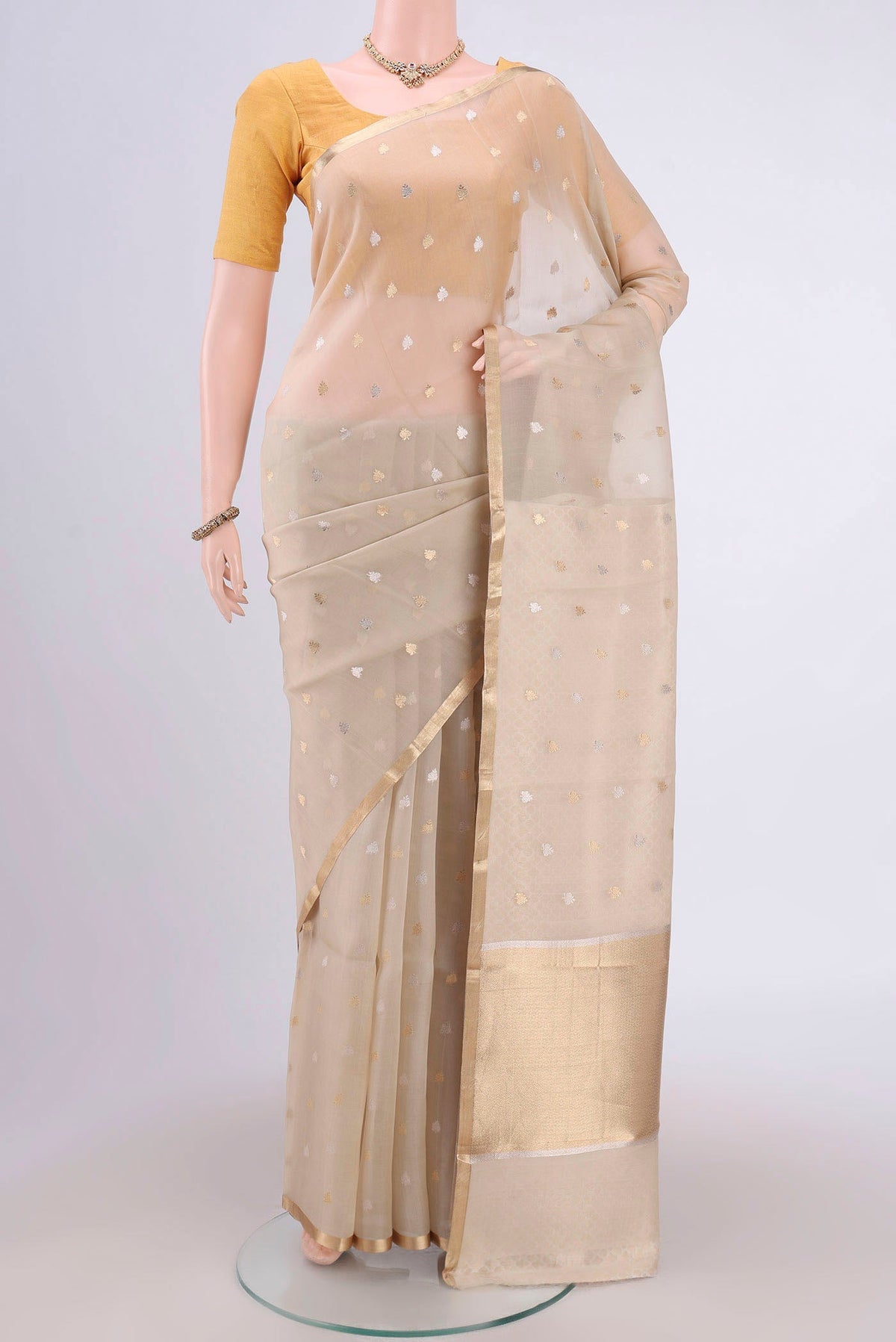 Beige Banarasi Katan Silk Saree with Zari Butta on the body and Zari Border.  displayed on a mannequin